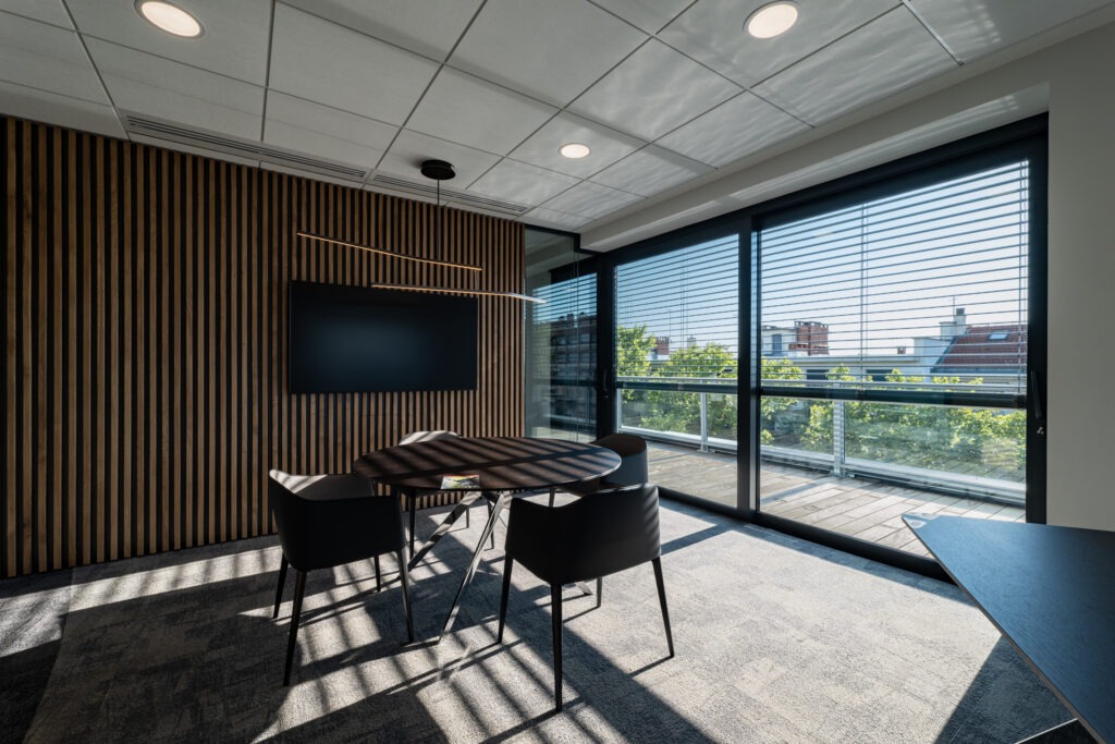 Salle de réunion moderne de l’Auxiliaire BTP avec murs en bois et grande baie vitrée à Lyon